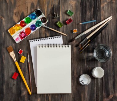 Kadar alay et. Yaratıcı alan. Koyu ahşap masa sanatsal çalışma araçları: sulu boya, Boya fırçaları ve su