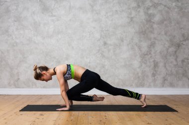 Genç kadın pratik yoga tahta poz, Dandasana tekstüre duvara / kentsel arka plan  