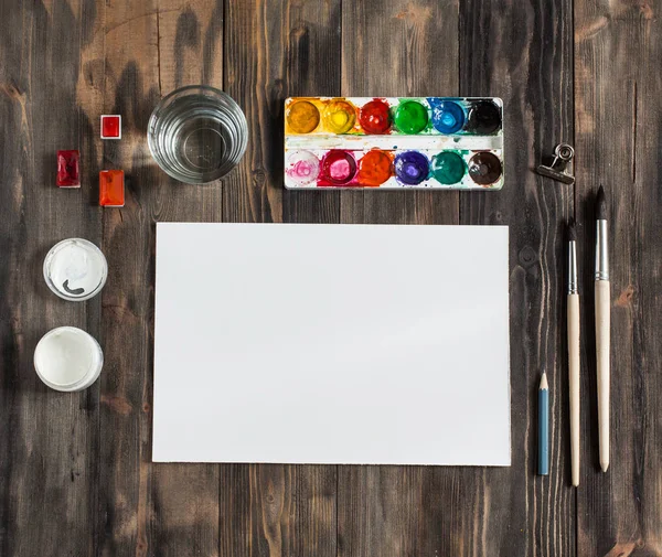 Kadar alay et. Yaratıcı alan. Koyu ahşap masa sanatsal çalışma araçları: sulu boya, Boya fırçaları ve su.