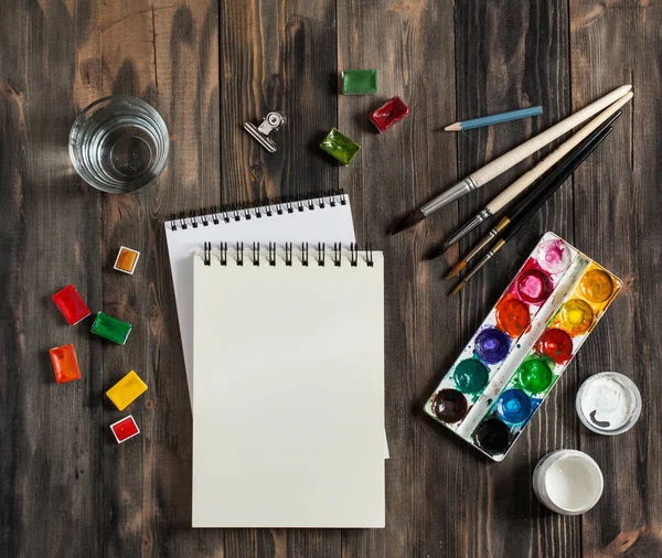 Kadar alay et. Yaratıcı alan. Koyu ahşap masa sanatsal çalışma araçları: sulu boya, Boya fırçaları ve su