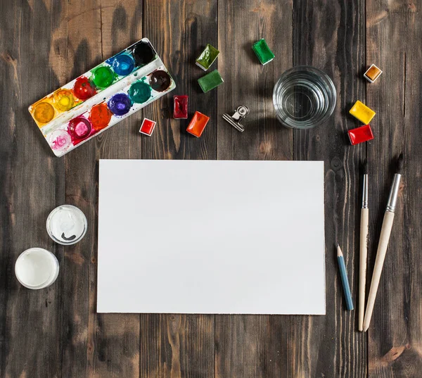 Kadar alay et. Yaratıcı alan. Koyu ahşap masa sanatsal çalışma araçları: sulu boya, Boya fırçaları ve su.