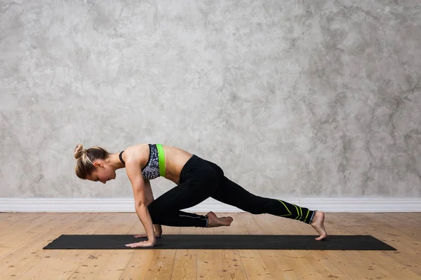 Genç kadın pratik yoga tahta poz, Dandasana tekstüre duvara / kentsel arka plan  