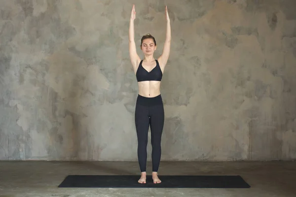 Mujer joven practicando yoga pose de montaña, Samasthiti contra pared texturizada / fondo urbano — Foto de Stock