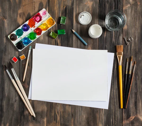 Kadar alay et. Yaratıcı alan. Koyu ahşap masa sanatsal çalışma araçları: sulu boya, Boya fırçaları ve su.