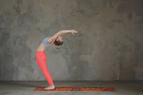 Jovem praticando Hasta Uttanasana, Raised Arms ioga pose contra parede texturizada / fundo urbano — Fotografia de Stock