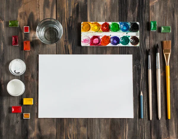 Kadar alay et. Yaratıcı alan. Koyu ahşap masa sanatsal çalışma araçları: sulu boya, Boya fırçaları ve su.
