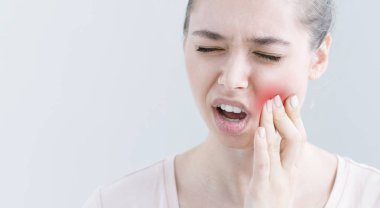 O bu sakin yanağa parmak baskı yapıyor çok güçlü ağrı hissi diş ağrısı, acı gri arka plan üzerinde izole genç Avrupa erkek portresi kapatın