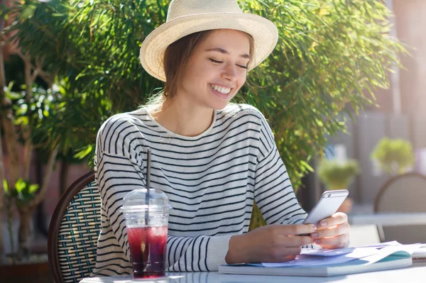 Yakışıklı Avrupa kız şapka ve çizgili top sevgili ve en yakın pozitif içerik paylaşımı telefonla iletişim sırasında açık kafe öğleden sonra harcama fotoğrafını yatay yaz