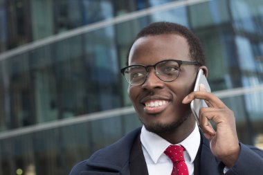 Ofis için iş bahsediyoruz arama gülümseyerek, smartphone, holding mutlu Afrika kökenli Amerikalı işadamı.