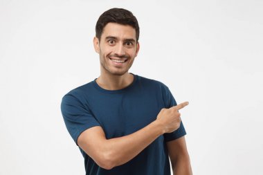 Mavi t-shirt şu gri arka plan üzerinde izole parmağıyla işaret içinde şık Avrupa adam