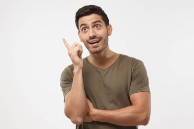 Yukarıya bakıyor ve işaret parmağı yükselterek, parlak fikir sahip olmak ya da ilginç yakışıklı genç adam sanıyordum, gri arka plan üzerinde izole bir şey anlama