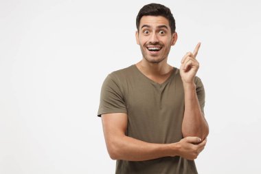 Ben harika bir fikir var! Genç çekici gülümseyen adam parmak tutmak yukarıya doğru işaret başının üzerinde bir şeyler gösteriyor, işaret parmağı ile jest yapma