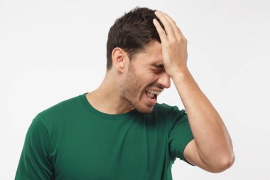 Hayal kırıklığına kapalı atış yeşil t-shirt yapımı facepalm el ile öğrenci dışarı vurguladı. Onun takımı Kupası ve futbol maç kaybetmek.  