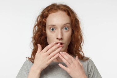 Ağız eller ve yuvarlak gözleri derin şaşkınlık ve korku yaşıyor kapsayan rahat kıyafetler giymiş beyaz arka plan üzerinde izole genç redhead Avrupa erkek yatay portre fotoğrafı