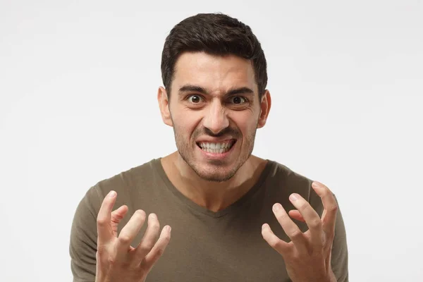 Shut up concept. Mad young man bite his teeth, gesturing with hands. Studio portrait of angry and irritated male yelling, looking crazy and full of anger — Stock Photo, Image