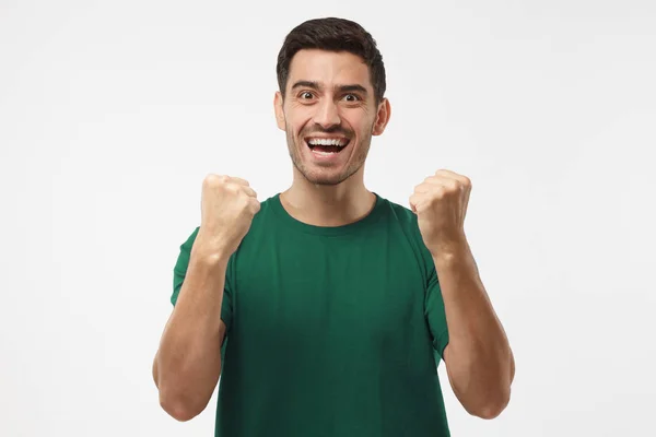 Fußballfan in grünem T-Shirt feiert Sieg seiner Mannschaft, schreiend, isoliert auf grauem Hintergrund Fußballfan in grünem T-Shirt feiert Sieg seiner Mannschaft, screami — Stockfoto