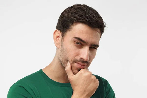 Acercamiento retrato de hombre sospechoso en camiseta verde, tratando de leer sus pensamientos, aislado sobre fondo gris — Foto de Stock