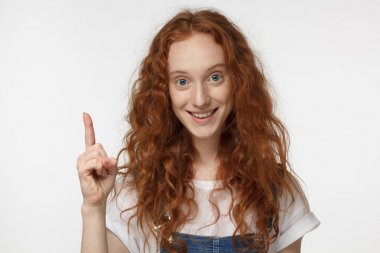 Bir fikrim var! Parmak tutmak güzel kızıl saçlı kız, başının üstünde bir şeyler gösteriyor, işaret parmağı ile jest yapma çekti. Eureka, çözüm oturum kavramı