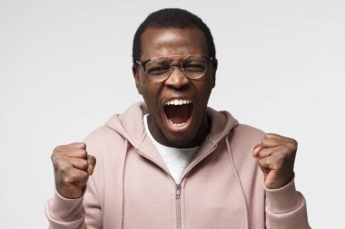 Kapa çeneni kavramı. Bağırarak, elleriyle işaret kızgın genç Afro-Amerikan adam. Bağırıyor, çılgın ve öfke dolu arıyor kızgın ve tahriş olmuş siyah erkek portresi stüdyo