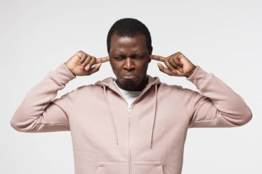 Kulakları ile hayal kırıklığına üzgünsün hoş olmayan bilgi veya yüz sorunlarını dinlemek istemediği kadar durdurma genç erkek resmedilmiştir izole üzerinde beyaz arka plan yatay çekim