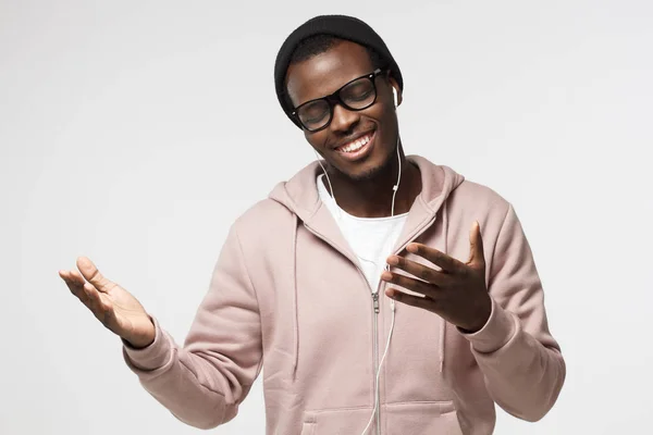 Junger gutaussehender afrikanisch-amerikanischer Mann mit Kopfhörer hört sein Lieblingslied, tanzt, lächelt mit geschlossenen Augen — Stockfoto