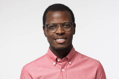 Gri arka plan üzerinde izole pembe gömlek gülümseyen yakışıklı Afrikalı-Amerikalı girişimci portresi kapatın