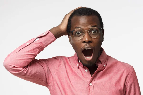 Casual gekleed jonge Afrikaanse zakenman in roze shirt schreeuwen oh mijn god met open mond, verrast door de lage prijs en verkoop, geïsoleerd op een grijze achtergrond — Stockfoto