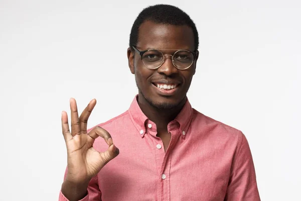 Jonge zwarte zakenman gelukkig kijken, glimlachen, gebaren, Ok teken tonen. Afrikaanse man weergegeven: Ok-gebaar met zijn vingers. Lichaamstaal concept — Stockfoto