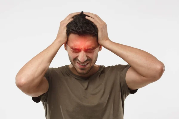 Agacé jeune homme malheureux serrant la tête avec les mains, souffrant de maux de tête. Personnes, stress, tension et migraine concept — Photo