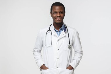 Portrait of handsome african american doctor isolated on gray background clipart