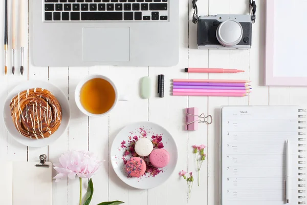 Collection of objects. Feminine flat lay workspace with laptop, cup of tea, macarons and flowers on white wooden table. Top view mock up. — Stock Photo, Image