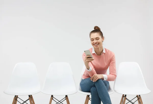 Úspěšný student ženské sedí v řádku, nosí brýle, sdílení novinky se svými přáteli prostřednictvím sociálních sítí — Stock fotografie