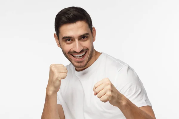 Närbild porträtt av leende ung man att hålla nävarna redo att kämpa och försvara sig själv. Stark sportiga mannen boxning, tittar på kamera med leende — Stockfoto