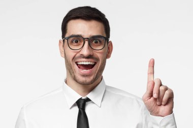 Bir fikrim var! Parmak tutmak yakışıklı iş adamı yukarı doğru başının üzerinde bir şeyler gösteriyor, işaret parmağı ile jest yapma çekti. Eureka, çözüm imzalamak