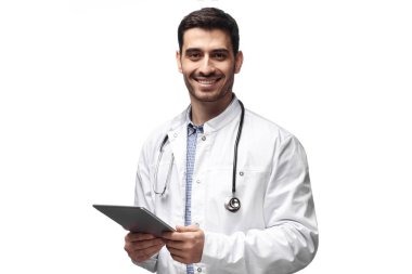 Yakışıklı doktor yalıtılmış ayakta tablet cihaz holding beyaz arka planda gösteren güven ve iyimserlik verirken düz açık göz ve gülümseyen