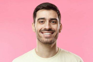 Genç adam, pembe arka plan izole gülümseyen fotoğrafını kapatın