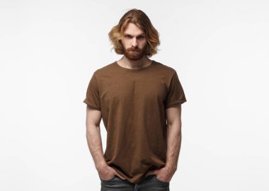 Ceplerinde gri arka plan üzerinde izole kahverengi tshirt genç Avrupa erkeksi sakallı adam ile ayakta eller