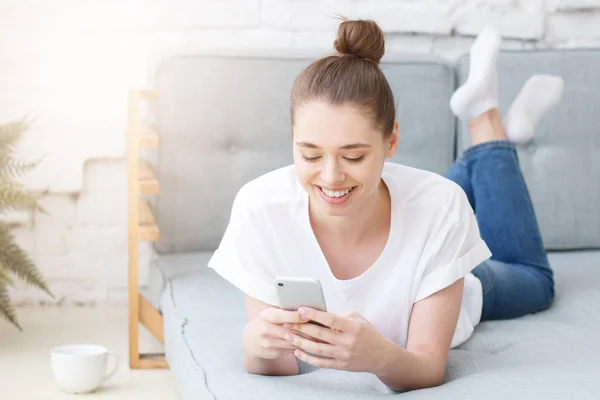 Šťastné veselé usmívající se mladá žena pomocí chytrého telefonu — Stock fotografie