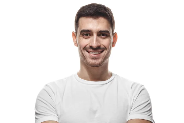 Närbild porträtt av leende stilig man i vit t-shirt tittar på kameran, isolerade — Stockfoto