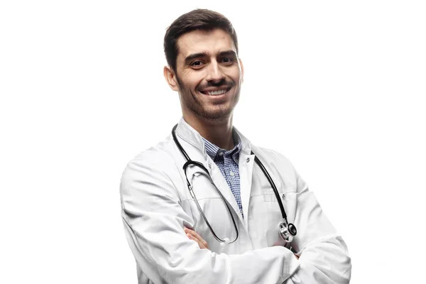 Homem sorridente médico posando com os braços cruzados, vestindo um estetoscópio, isolado em fundo branco — Fotografia de Stock
