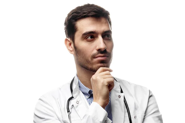 Imagen del joven doctor pensando en el tratamiento aislado sobre fondo blanco —  Fotos de Stock