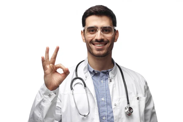 Retrato de hombre médico sonriendo y mostrando signo de bien —  Fotos de Stock