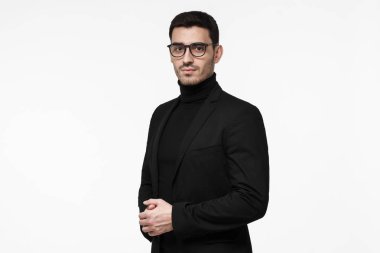 Siyah boğazlı kazak, gözlük ve ceket, ciddi ve ayrılmış, karmaşık soruları cevaplamak hazır arıyorum genç yakışıklı beyaz adam beyaz arka plan üzerinde izole varoluş portresi giymiş