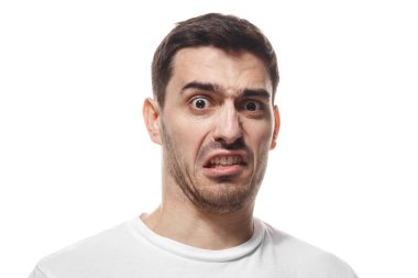 Genç Beyaz adam nefretle güçlü duygu sanki bir pis koku ya da hoş olmayan bir şey araya geldi gösterilen beyaz boş T-shirt giyen beyaz arka plan üzerinde izole closeup headshot