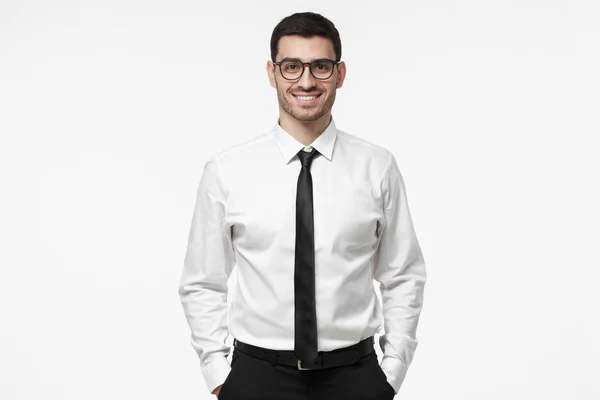 Indoor portrait of handsome European businessman pictured isolated on white background dressed in white formal shirt and black tie standing in front of camera, feeling positive, confident and calm — Stock Photo, Image