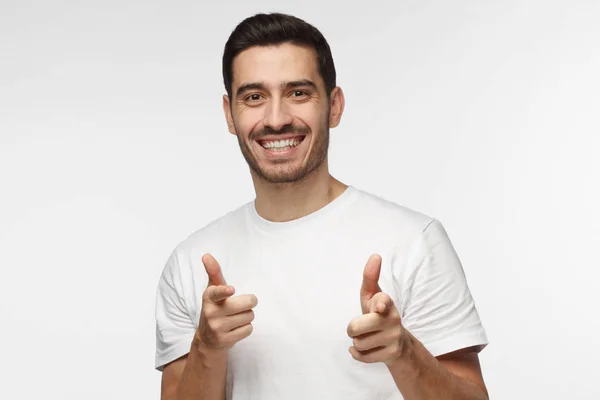 Detailní portrét mladých šťastný Evropské kavkazské muž izolované na šedém pozadí s úsměvem při pohledu na fotoaparát ukazující na prohlížeč s prsty obou rukou, jako by schvalování a pocit radost — Stock fotografie