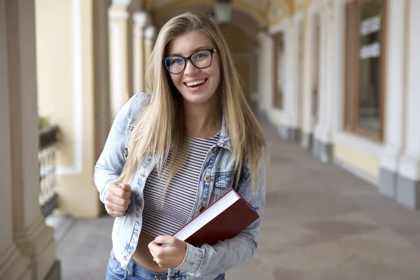 Giovane studentessa con i capelli lunghi e occhiali felicemente ballare e — Foto Stock