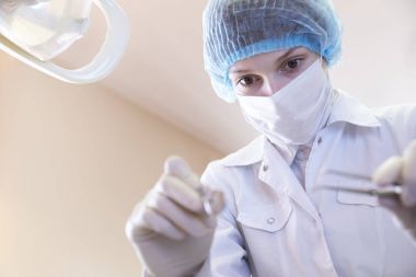 tıbbi maskesi, şapka ve eldiven bir concentrat ile kadın diş hekimi