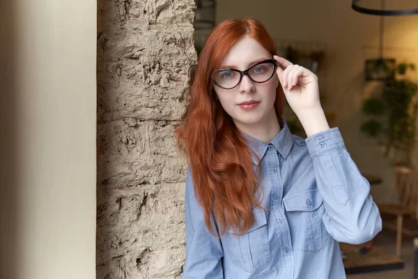 Крупным планом портрет молодой рыжей девушки в очках, стоящей — стоковое фото