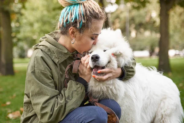 Porträtt av en ung kvinna i en grön kappa och dreadlocks, kissin — Stockfoto